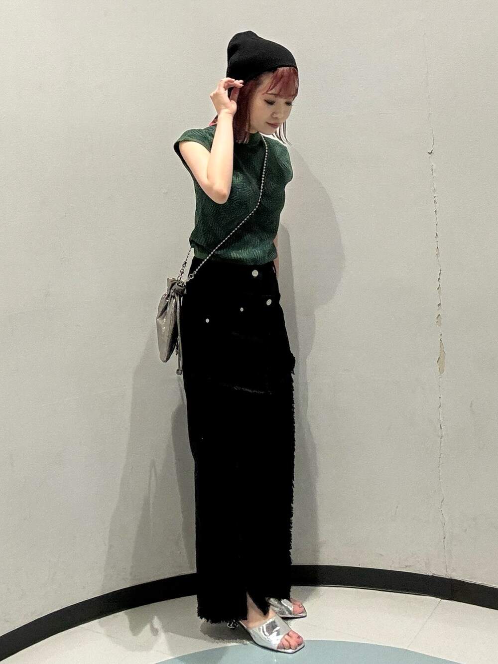 グリーン系のニット/セーター、ブラック系のデニムパンツ、シルバー系のサンダルを着用したレディースの夏コーディネートの2枚目の写真