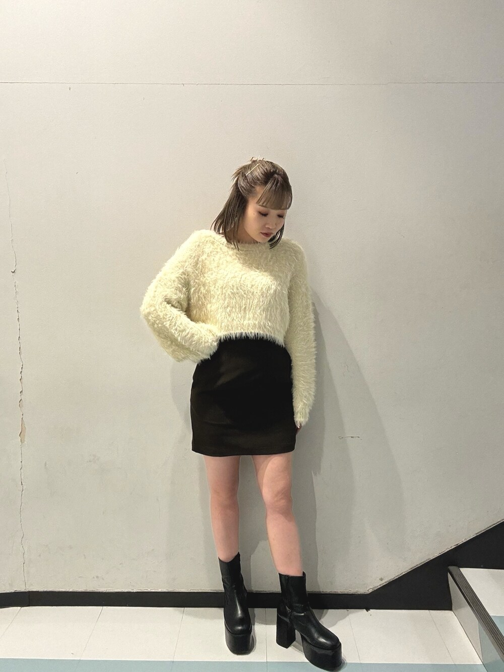 ブルー系のピーコート、ホワイト系のニット/セーター、ブラック系のスカートを着用したレディースの秋コーディネートの6枚目の写真