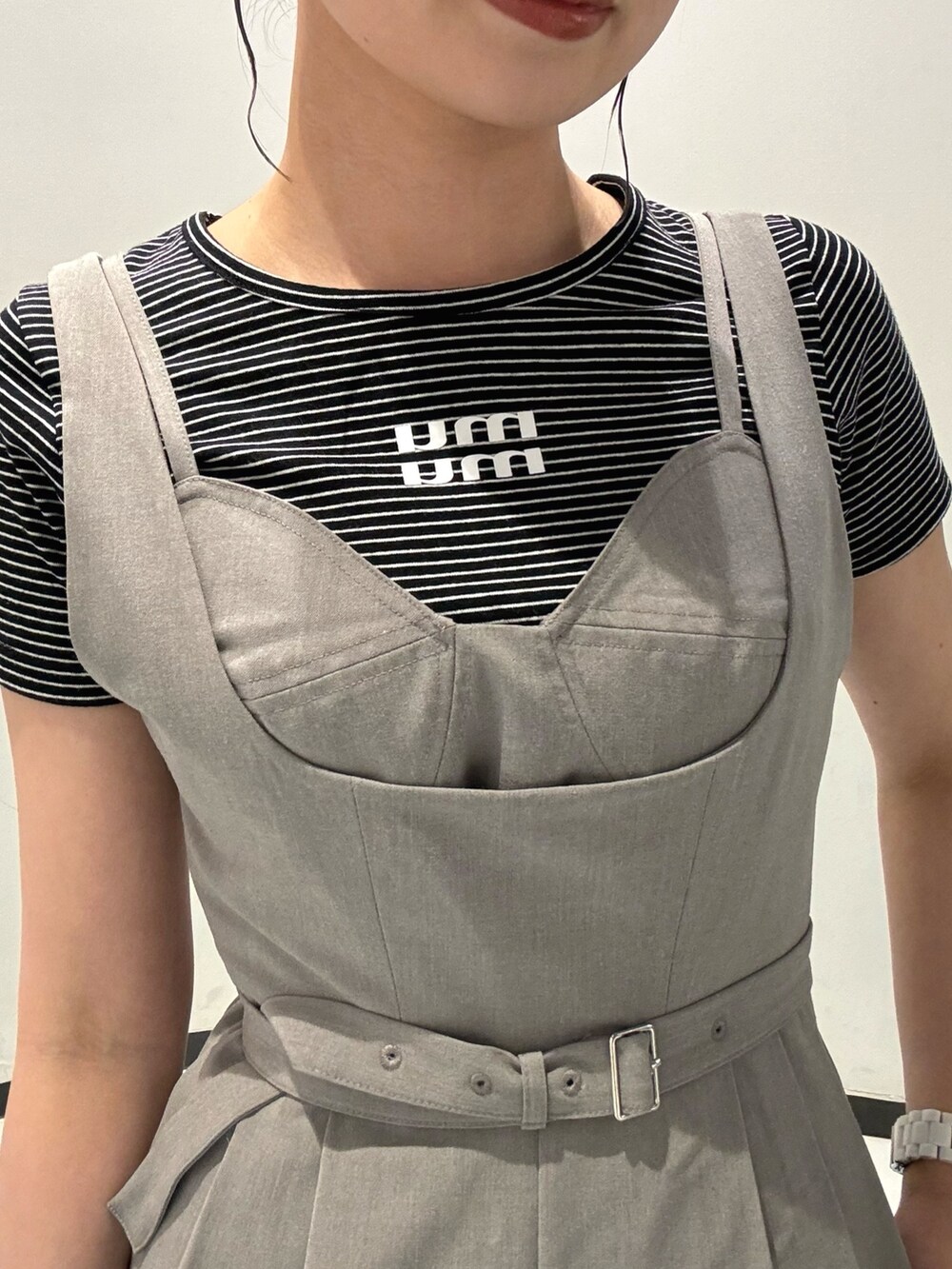 グレー系のワンピース、ブラック系のショルダーバッグ、シルバー系のサンダルを着用したレディースの春コーディネートの4枚目の写真