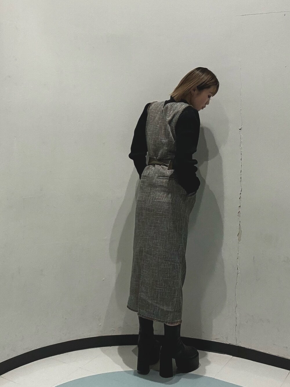 グレー系のダウンジャケット/コート、ブラック系のニット/セーター、グレー系のワンピースを着用したレディースの冬コーディネートの4枚目の写真