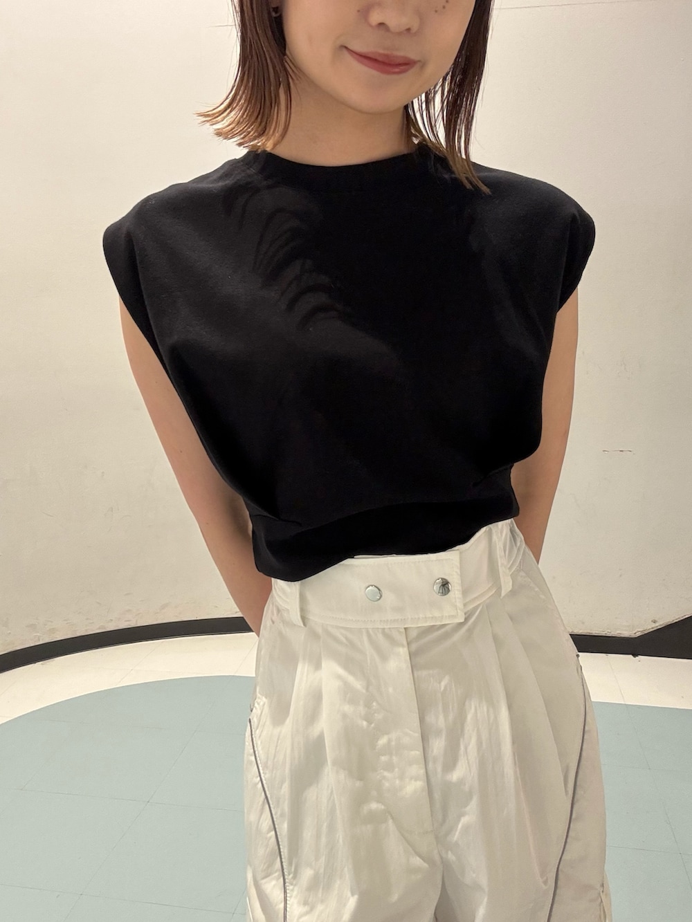 ブラック系のTシャツ/カットソー、ブラック系のサンダル、ブラウン系のハンドバッグを着用したレディースの夏コーディネートの4枚目の写真