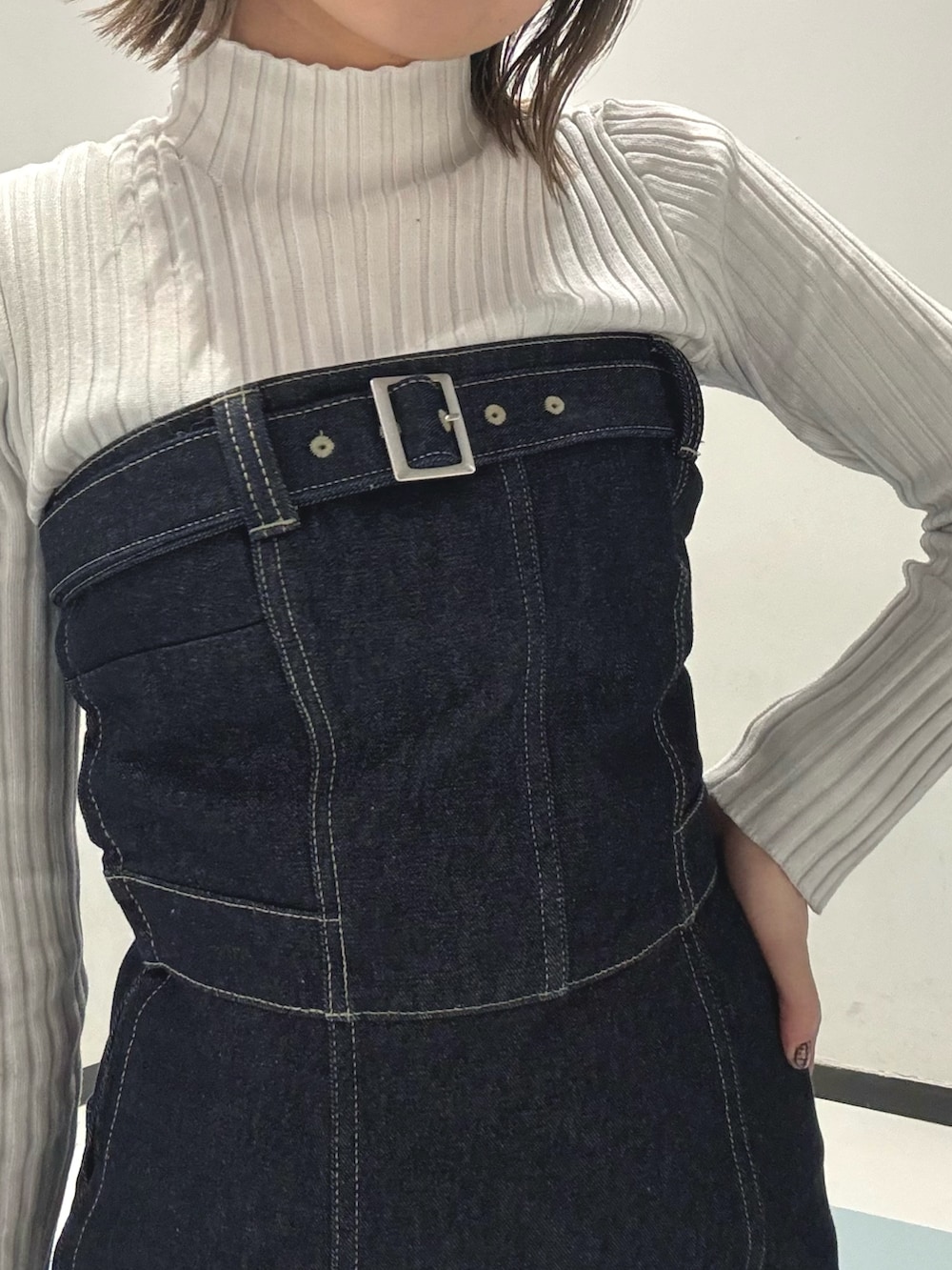 ブラック系のハンドバッグ、ブルー系のデニムジャケット、ブルー系のワンピースを着用したレディースの冬コーディネートの6枚目の写真