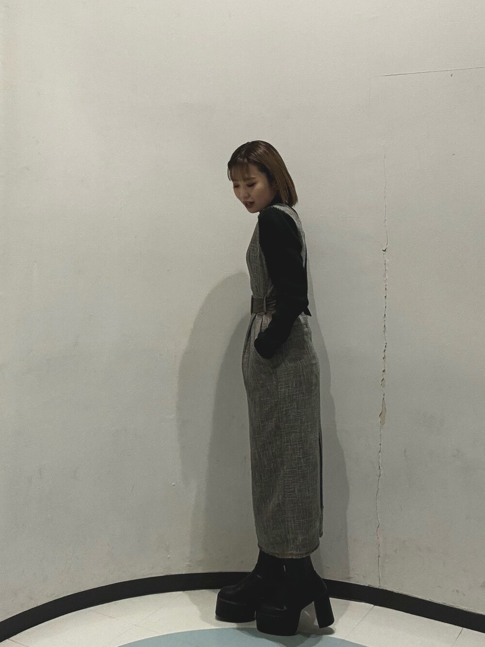 グレー系のダウンジャケット/コート、ブラック系のニット/セーター、グレー系のワンピースを着用したレディースの冬コーディネートの5枚目の写真