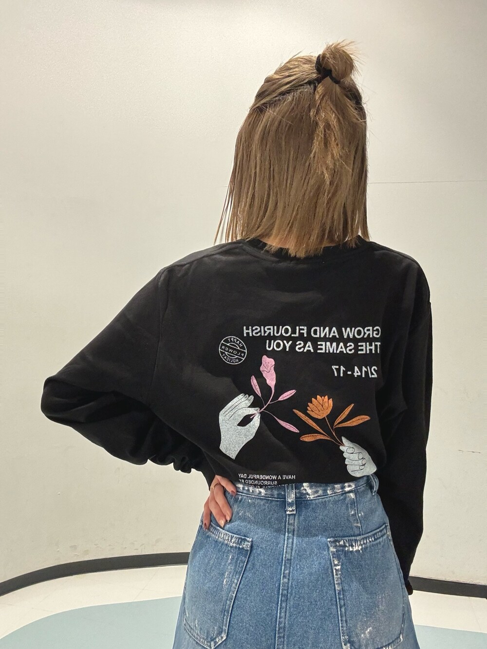 ブルー系のデニムパンツ、ブラック系のショルダーバッグ、グレー系のブルゾンを着用したレディースの冬コーディネートの4枚目の写真