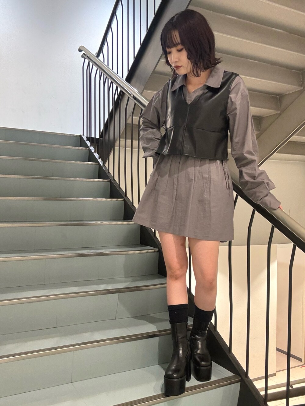 ブラック系のブーツ、グレー系のワンピースを着用したレディースの秋コーディネートの5枚目の写真