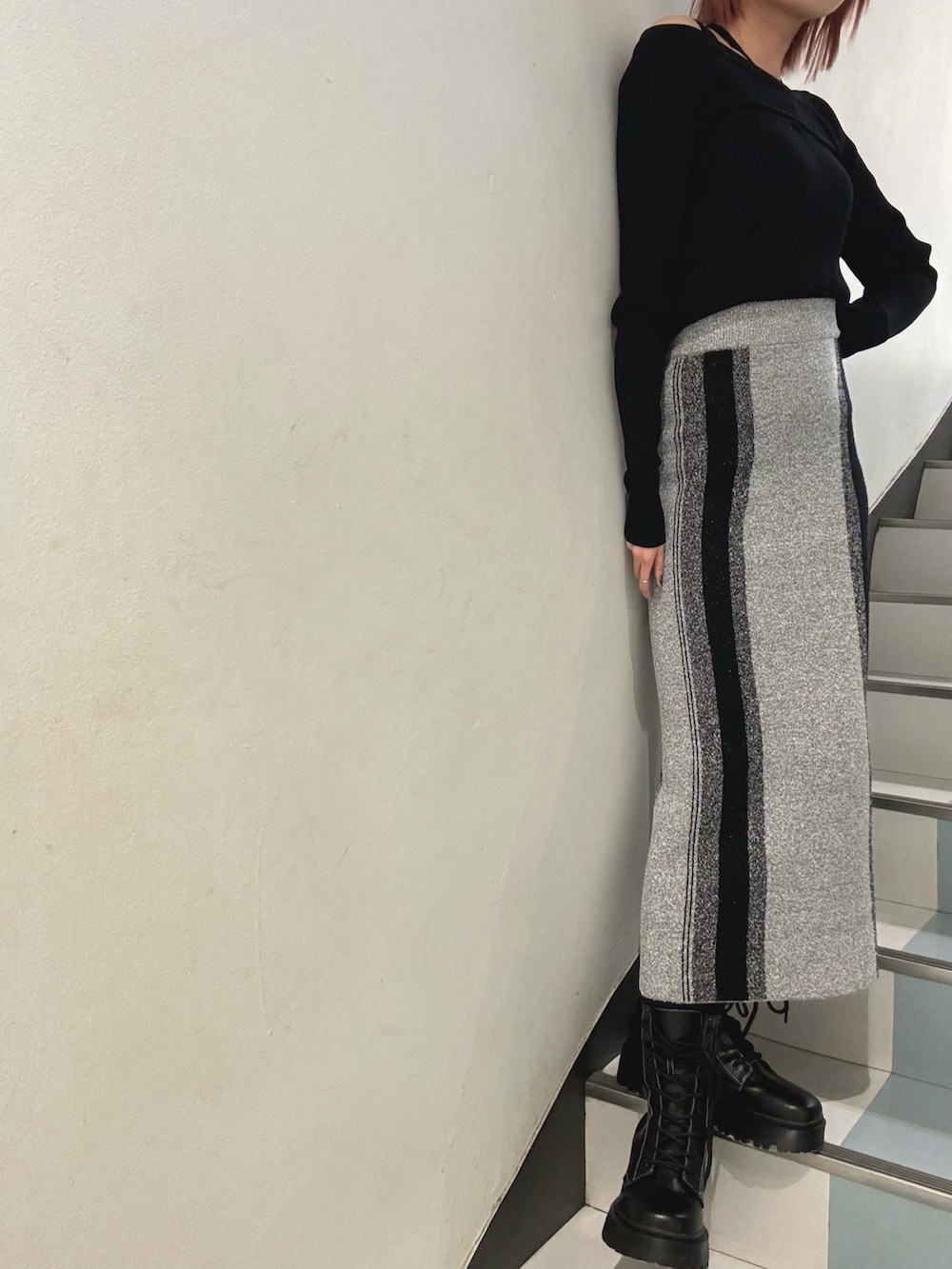 ブラック系のブーツ、シルバー系のハンドバッグ、グレー系のスカートを着用したレディースの冬コーディネートの5枚目の写真