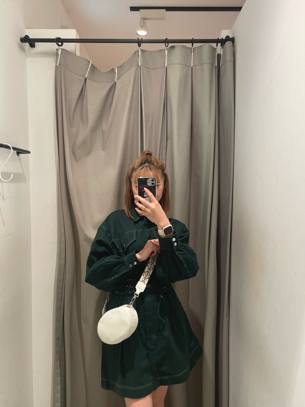 ホワイト系のショルダーバッグ、グリーン系のワンピースを着用したレディースの秋コーディネートの3枚目の写真