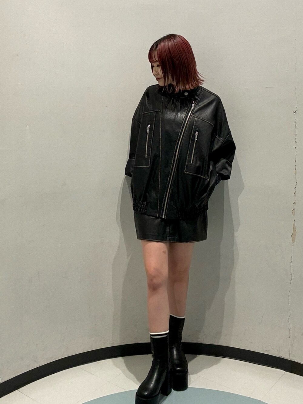 ブルー系のTシャツ/カットソー、ブラック系のライダースジャケット、ブラック系のスカートを着用したレディースの秋コーディネートの6枚目の写真