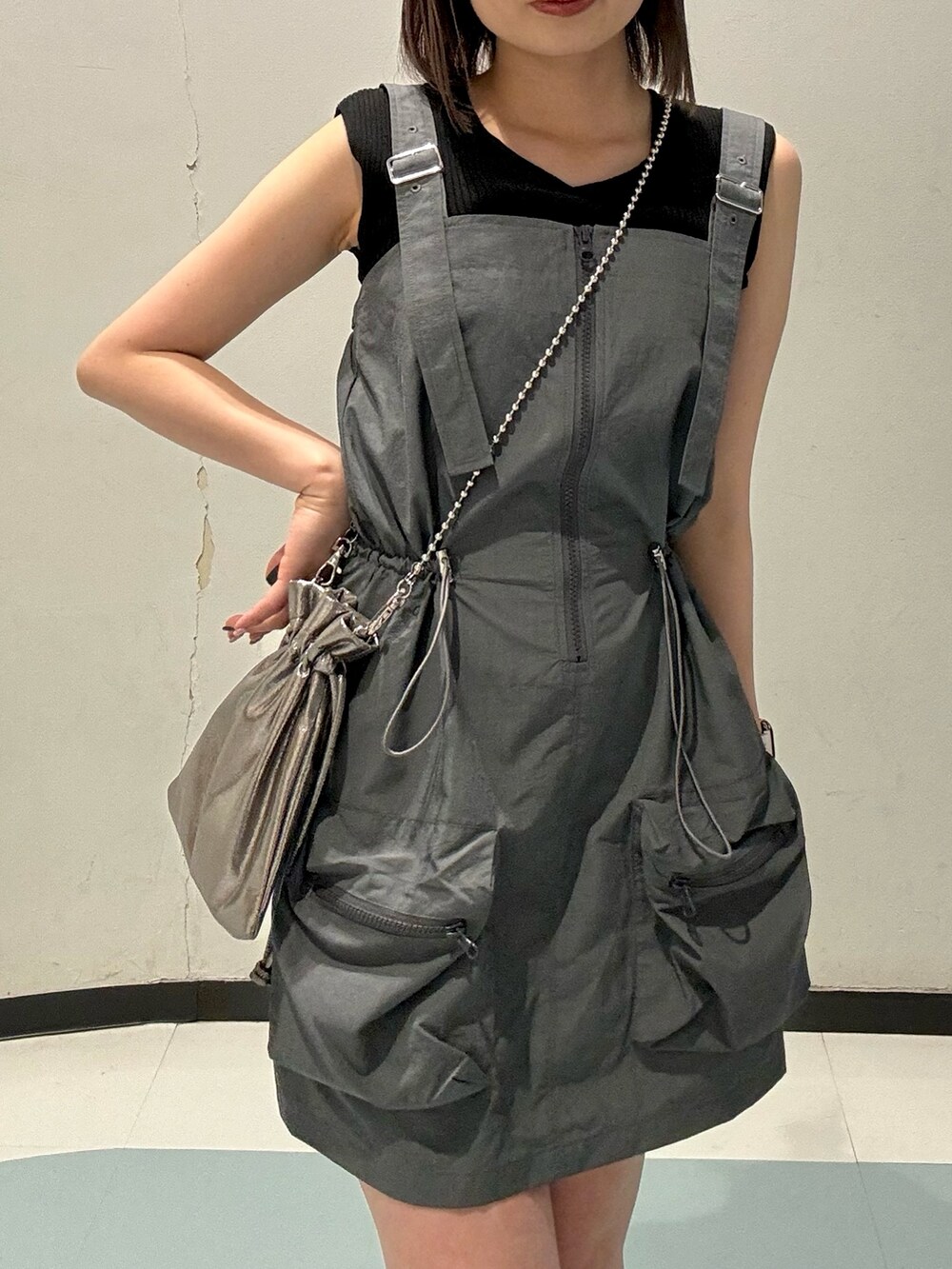 ブラック系のローファー、オレンジ系のニット/セーター、グレー系のワンピースを着用したレディースの春コーディネートの4枚目の写真