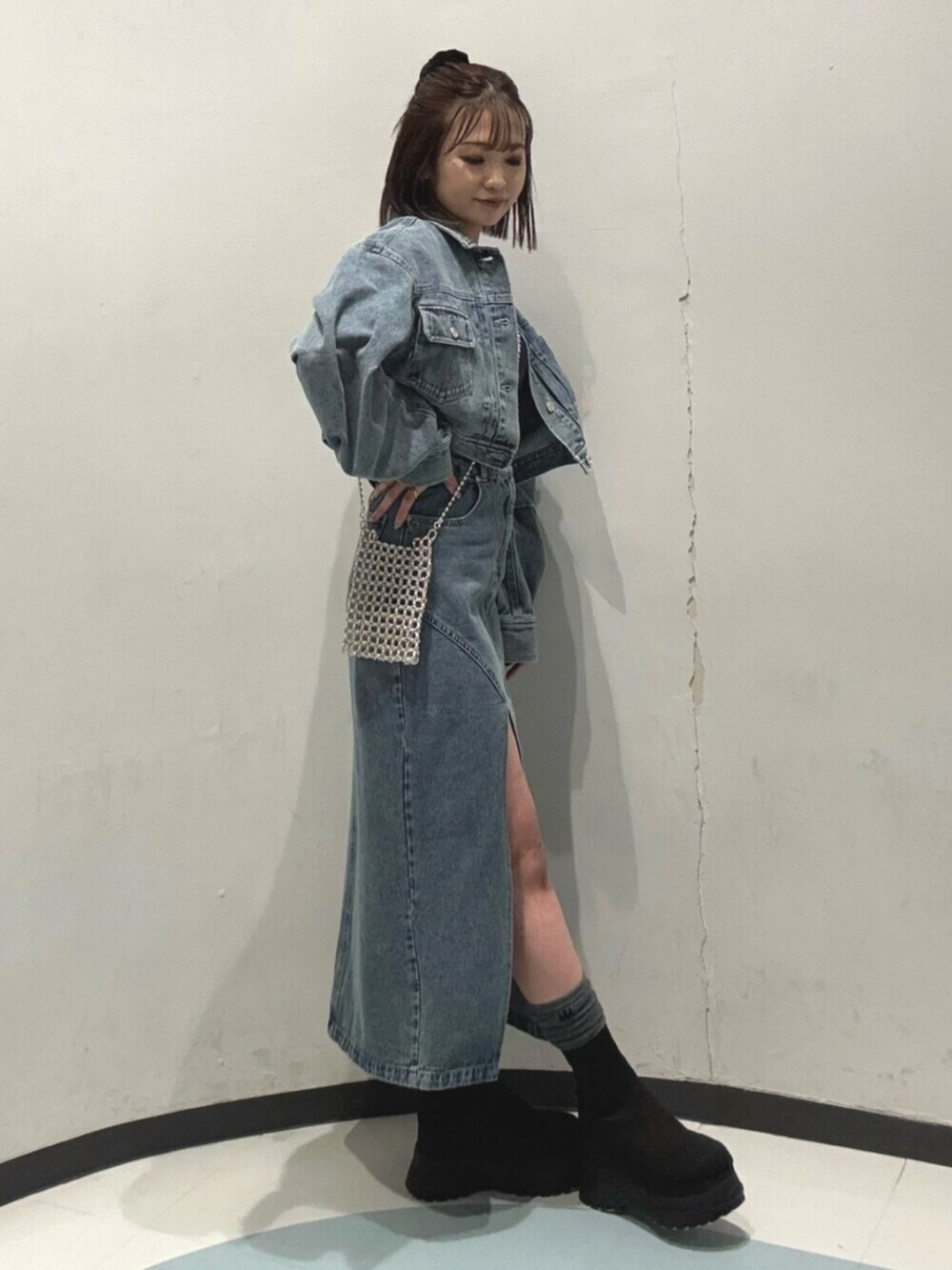 ブルー系のデニムジャケット、ブルー系のデニムスカート、ブルー系のTシャツ/カットソーを着用したレディースの冬コーディネートの2枚目の写真