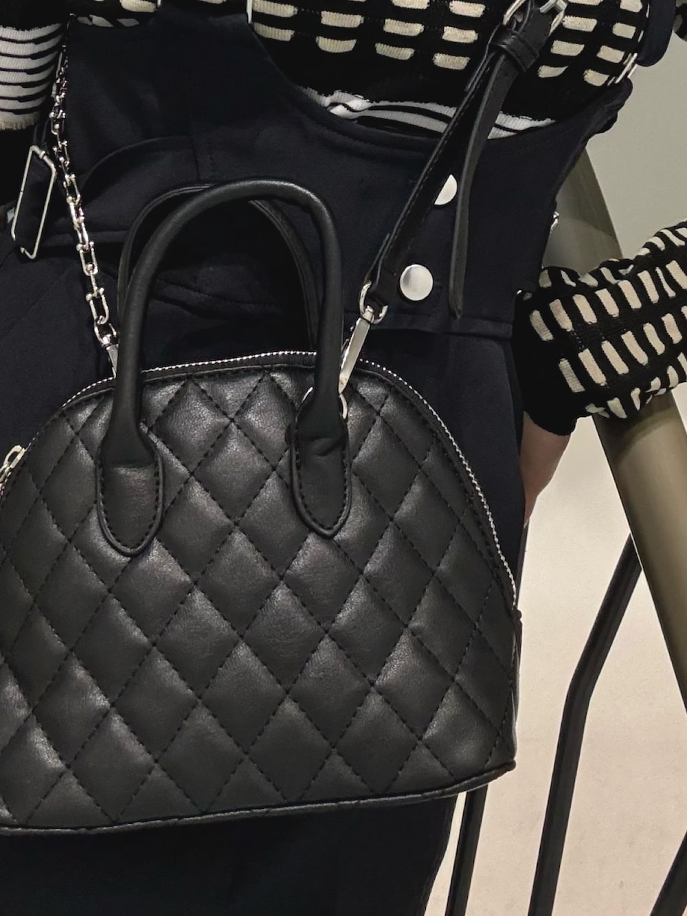 ブルー系のワンピース、ブラック系のハンドバッグ、ブラック系のブーツを着用したレディースの冬コーディネートの6枚目の写真