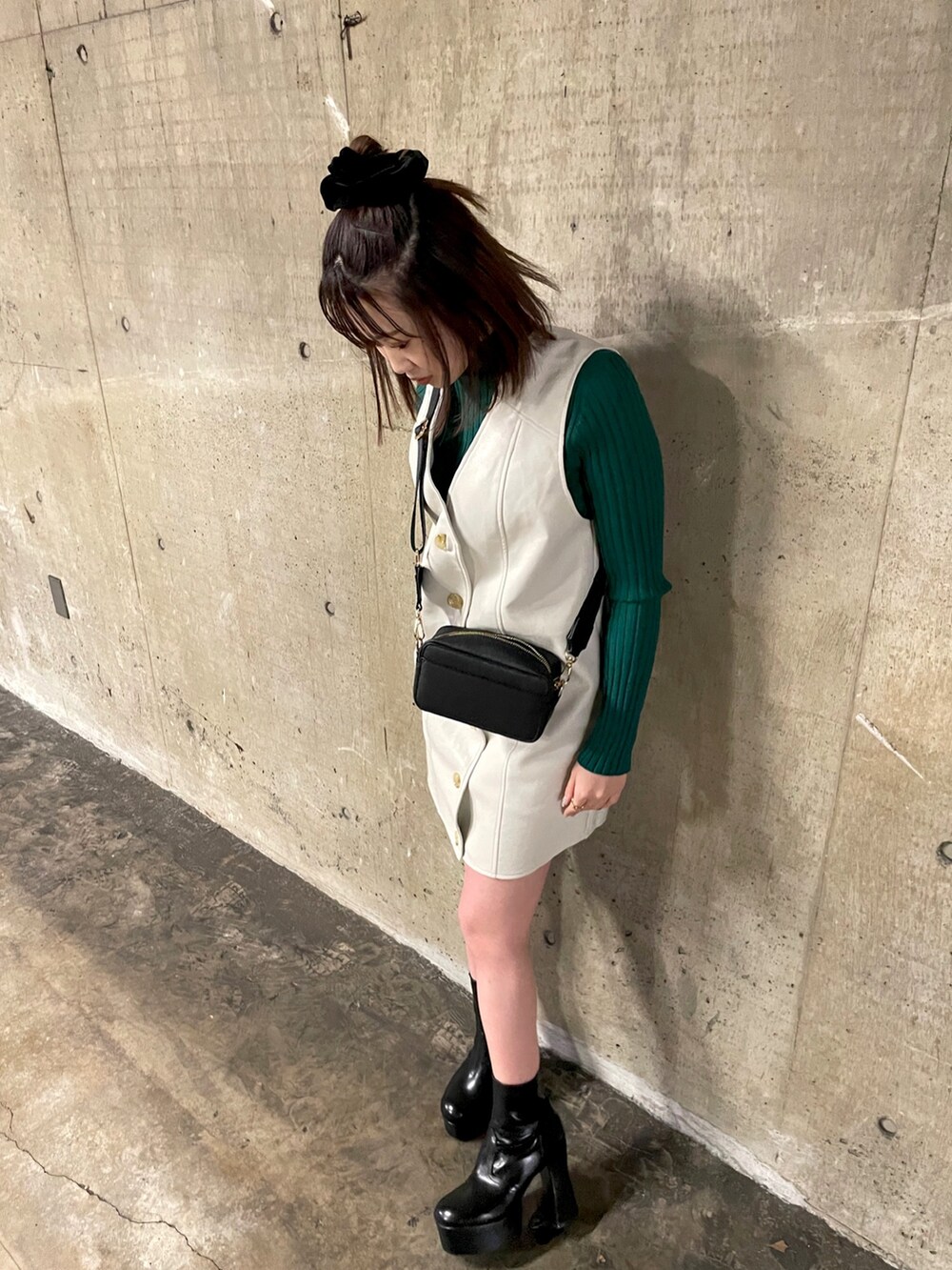 ブラック系のショルダーバッグ、グリーン系のニット/セーター、ホワイト系のワンピースを着用したレディースの冬コーディネートの3枚目の写真