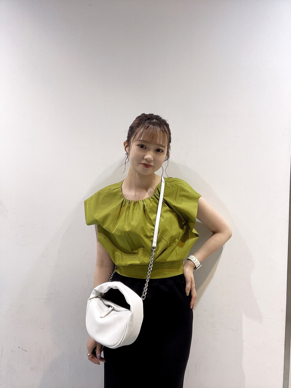 イエロー系のシャツ/ブラウス、ホワイト系のハンドバッグ、ブラック系のサンダルを着用したレディースの春コーディネートの3枚目の写真