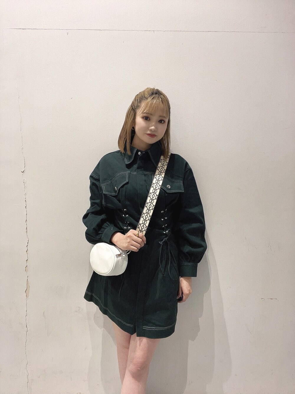 ホワイト系のショルダーバッグ、グリーン系のワンピースを着用したレディースの秋コーディネートの2枚目の写真