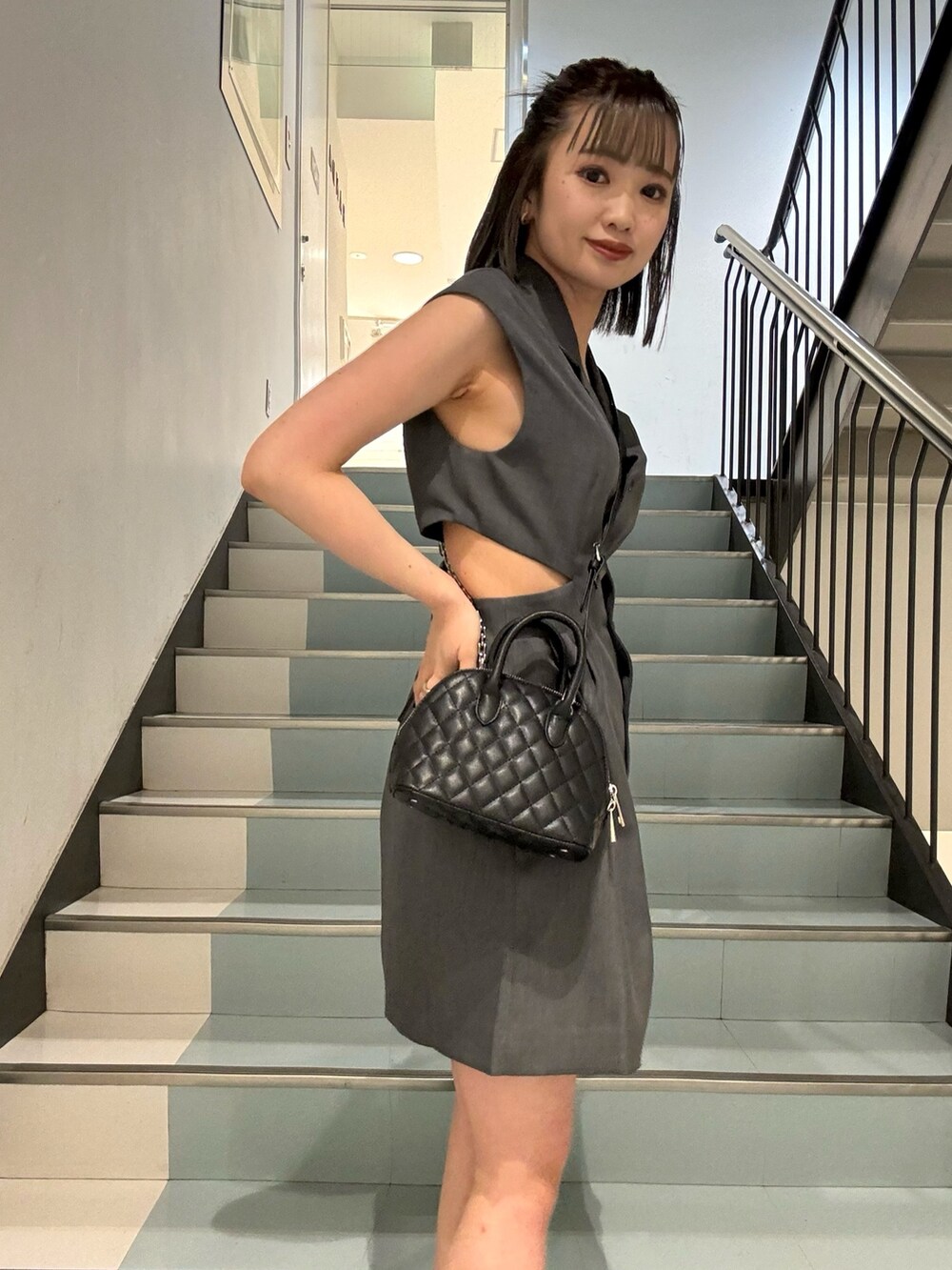 ブラック系のハンドバッグ、グレー系のワンピースを着用したレディースの春コーディネートの7枚目の写真