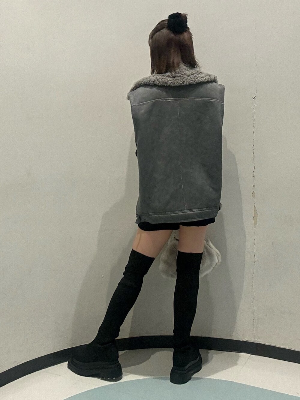 ブラック系のニット/セーター、ブラック系のその他パンツ、グレー系のムートンコートを着用したレディースの秋コーディネートの3枚目の写真