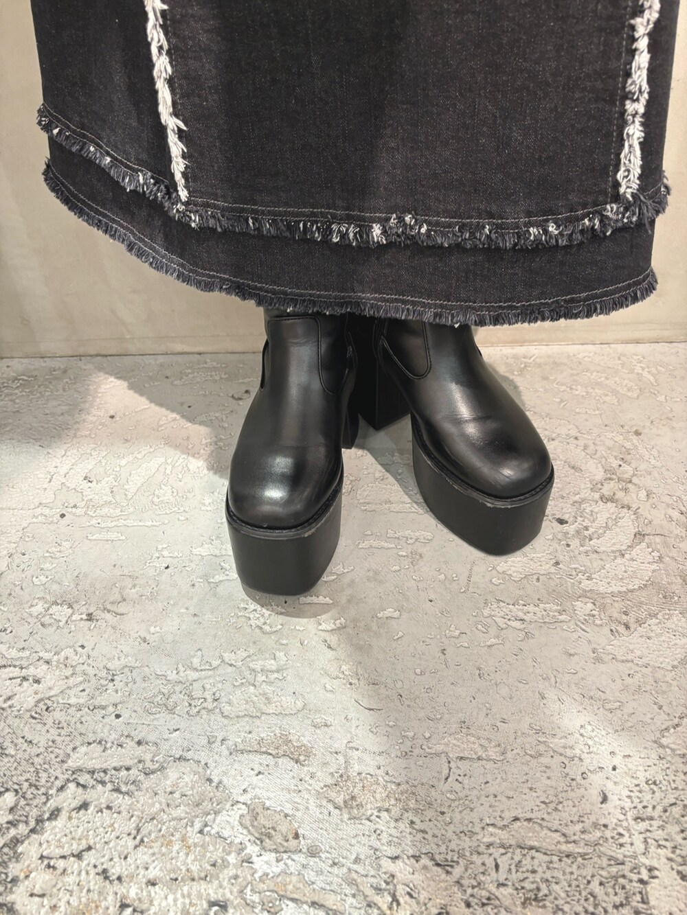 ブラック系のデニムスカート、グレー系のTシャツ/カットソー、ブラック系のハンドバッグを着用したレディースの冬コーディネートの7枚目の写真