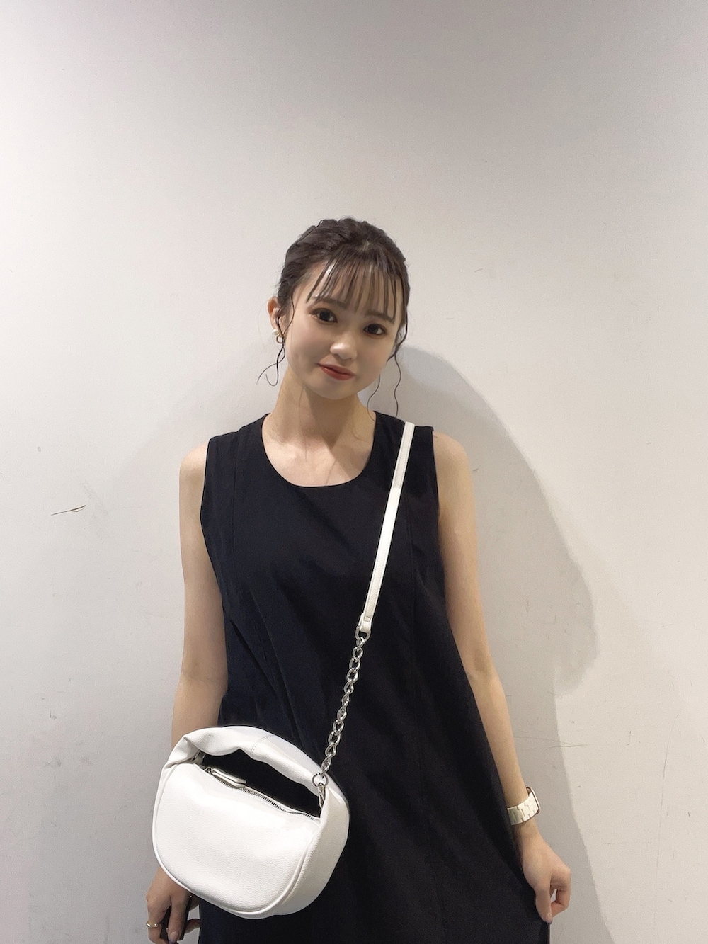 ブルー系のシャツ/ブラウス、ホワイト系のハンドバッグ、ブラック系のサンダルを着用したレディースの夏コーディネートの2枚目の写真