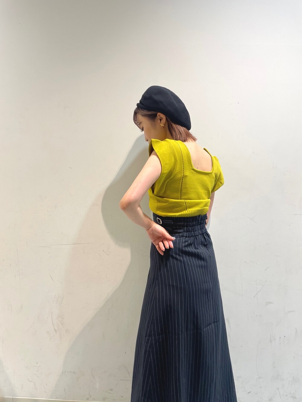 イエロー系のニット/セーター、ブラック系のサンダル、その他のスカートを着用したレディースの夏コーディネートの3枚目の写真