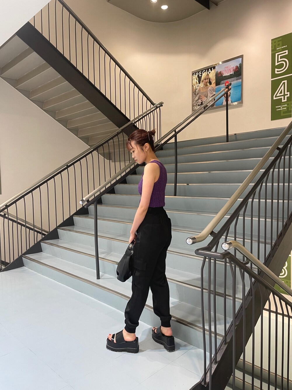 パープル系のタンクトップ、ブラック系のサンダル、ブラック系のスウェットパンツを着用したレディースの夏コーディネートの4枚目の写真