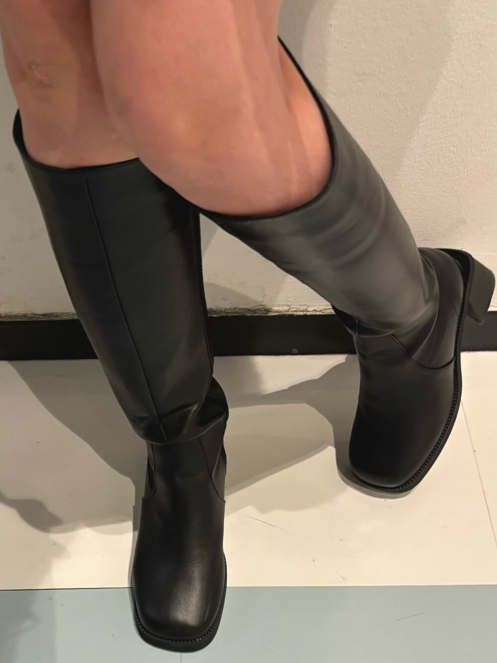 ブラック系のハンドバッグ、グレー系のニット/セーター、ブラック系のブーツを着用したレディースの秋コーディネートの7枚目の写真