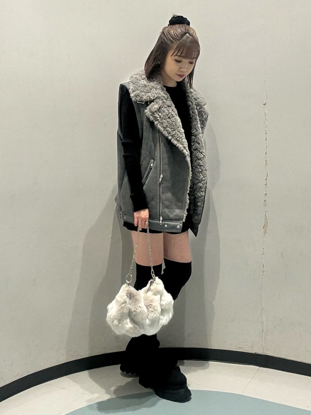 ブラック系のニット/セーター、ブラック系のその他パンツ、グレー系のムートンコートを着用したレディースの秋コーディネートの2枚目の写真