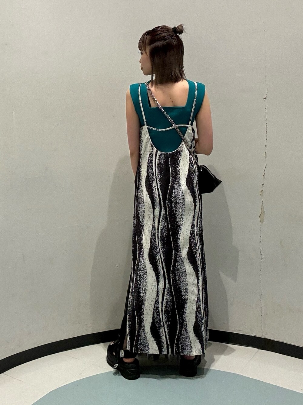 ブラック系のワンピース、ブラック系のハンドバッグ、グリーン系のニット/セーターを着用したレディースの春コーディネートの3枚目の写真