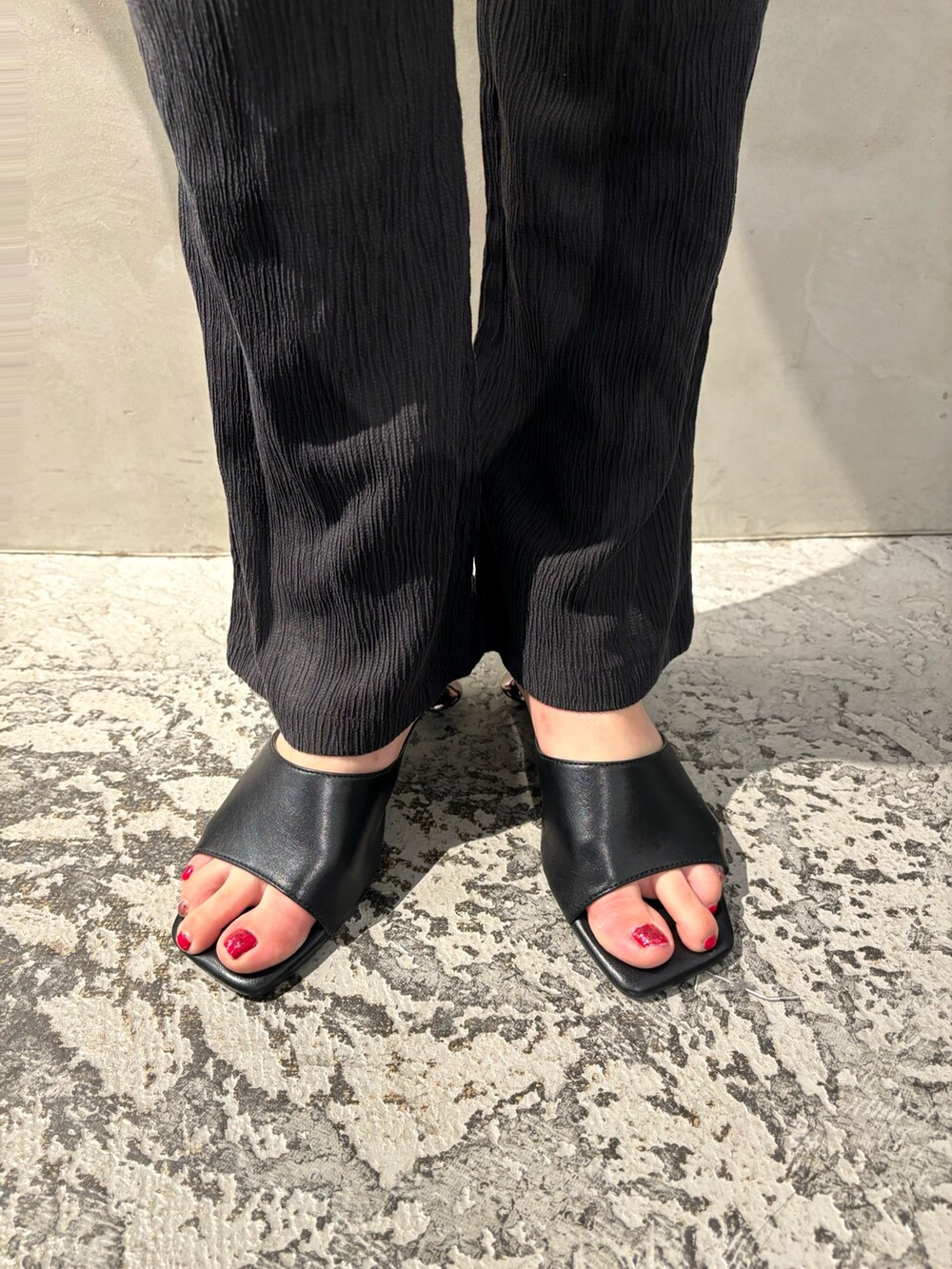 オレンジ系のショルダーバッグ、ブラック系のニット/セーター、オレンジ系のワンピースを着用したレディースの夏コーディネートの7枚目の写真