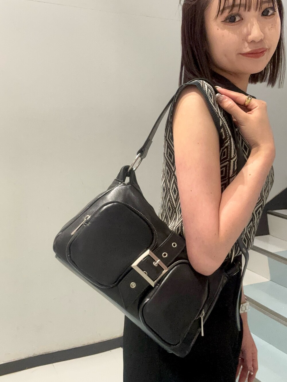 ホワイト系のサンダル、ブラック系のハンドバッグ、グリーン系のタンクトップを着用したレディースの夏コーディネートの5枚目の写真