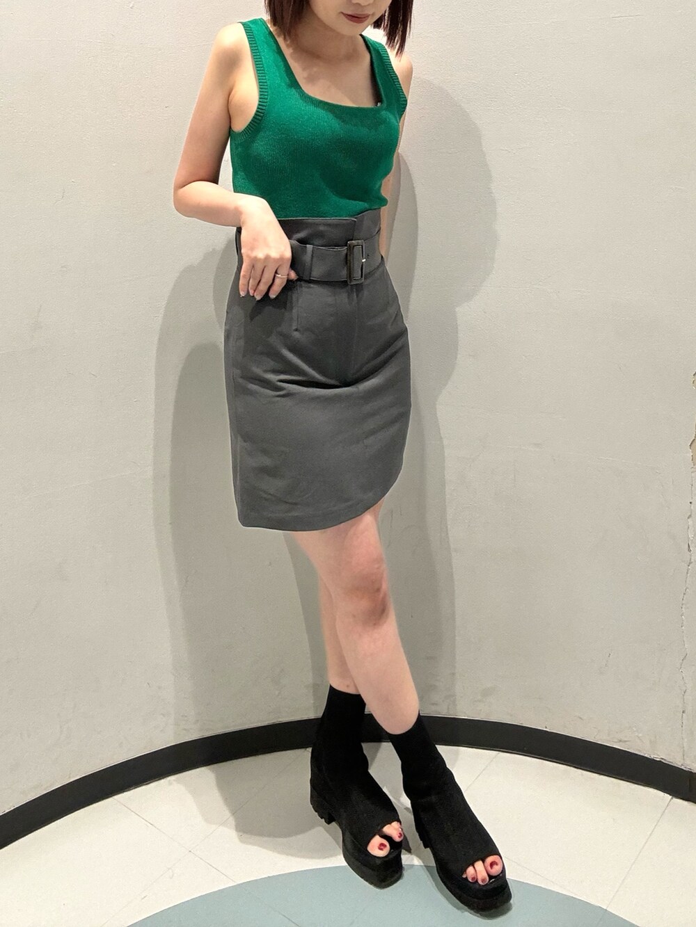 ブラック系のショルダーバッグ、グレー系のベスト、ブラック系のブーツを着用したレディースの夏コーディネートの7枚目の写真