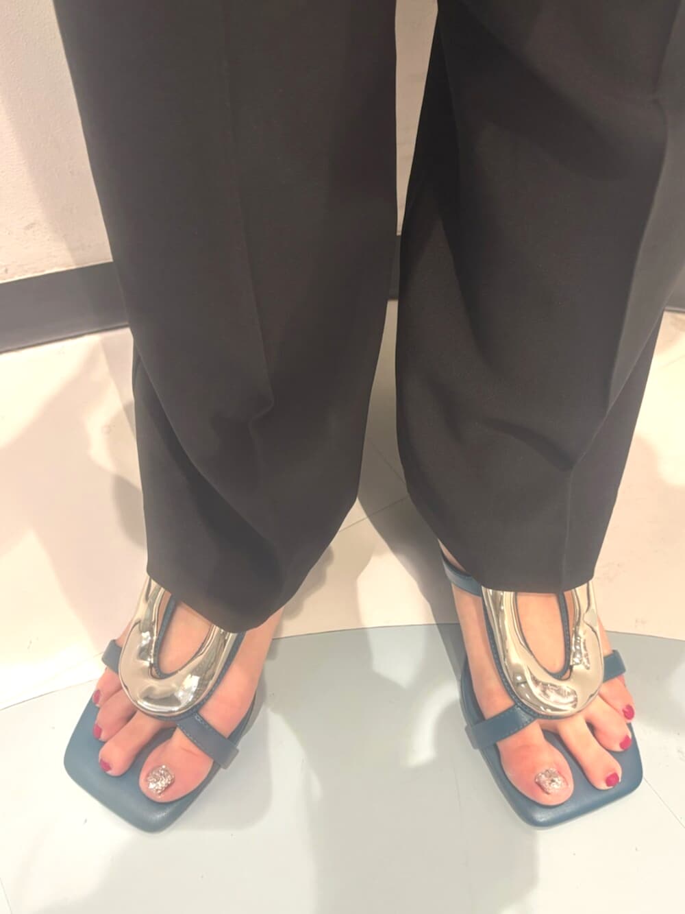 ブルー系のサンダル、ブラック系のスラックス、ホワイト系のTシャツ/カットソーを着用したレディースの夏コーディネートの7枚目の写真