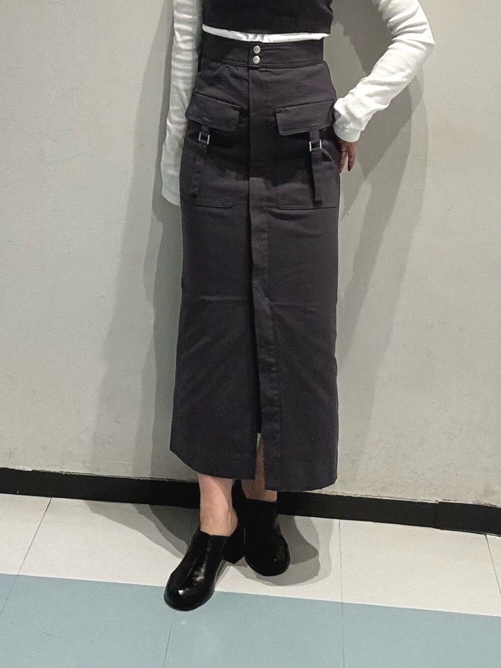 ホワイト系のTシャツ/カットソー、グレー系のワンピース、ブラック系のサンダルを着用したレディースの冬コーディネートの7枚目の写真