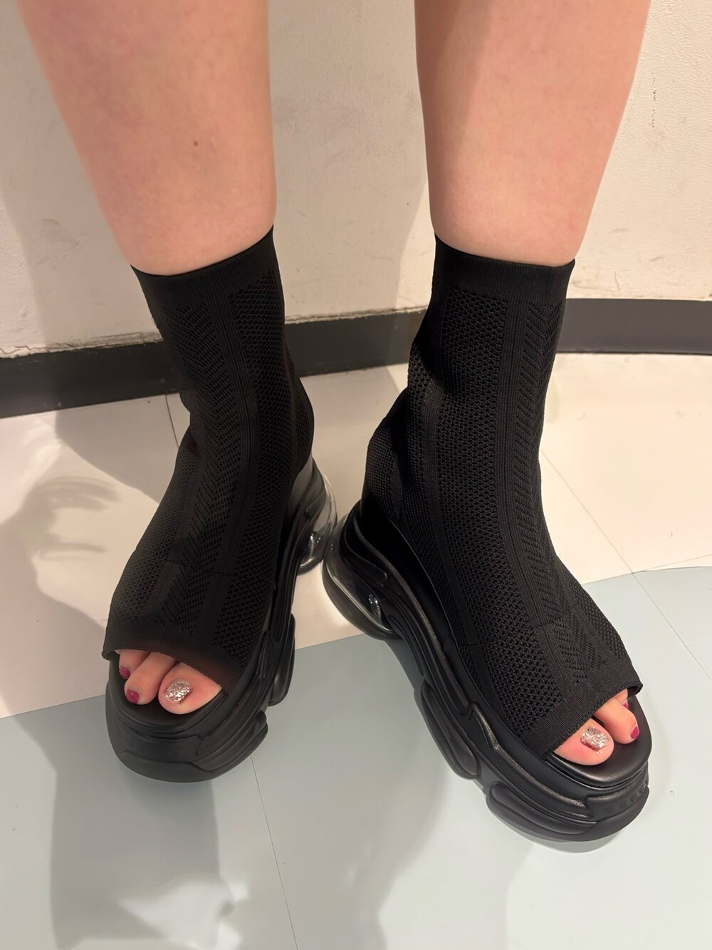 ブラック系のニット/セーター、ブラック系のサンダル、グレー系のスカートを着用したレディースの夏コーディネートの7枚目の写真