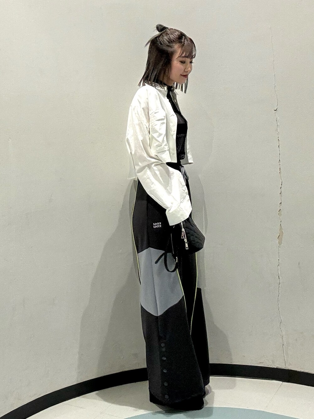 ブラック系のハンドバッグ、ブラック系のニット/セーター、グレー系のその他パンツを着用したレディースの春コーディネートの2枚目の写真