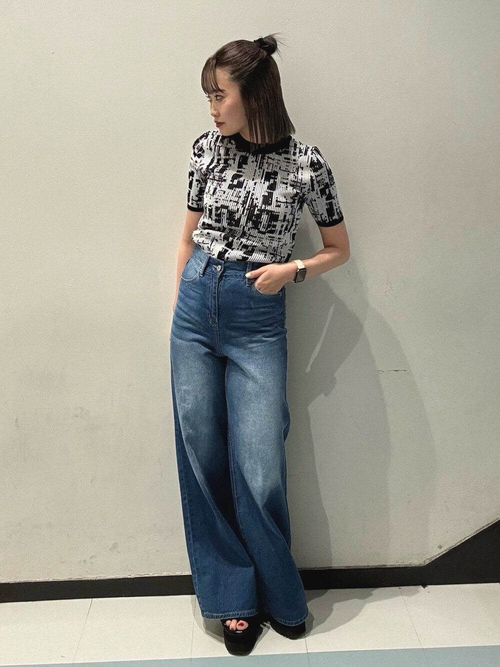 ブラック系のショルダーバッグ、ブラック系のシャツ/ブラウス、ブルー系のデニムパンツを着用したレディースの春コーディネートの6枚目の写真