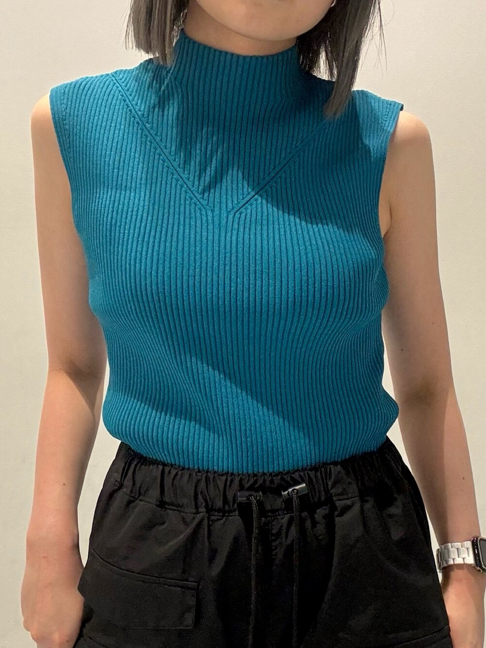 ピンク系のシャツ/ブラウス、ブルー系のニット/セーター、ブラック系のカーゴパンツを着用したレディースの春コーディネートの4枚目の写真