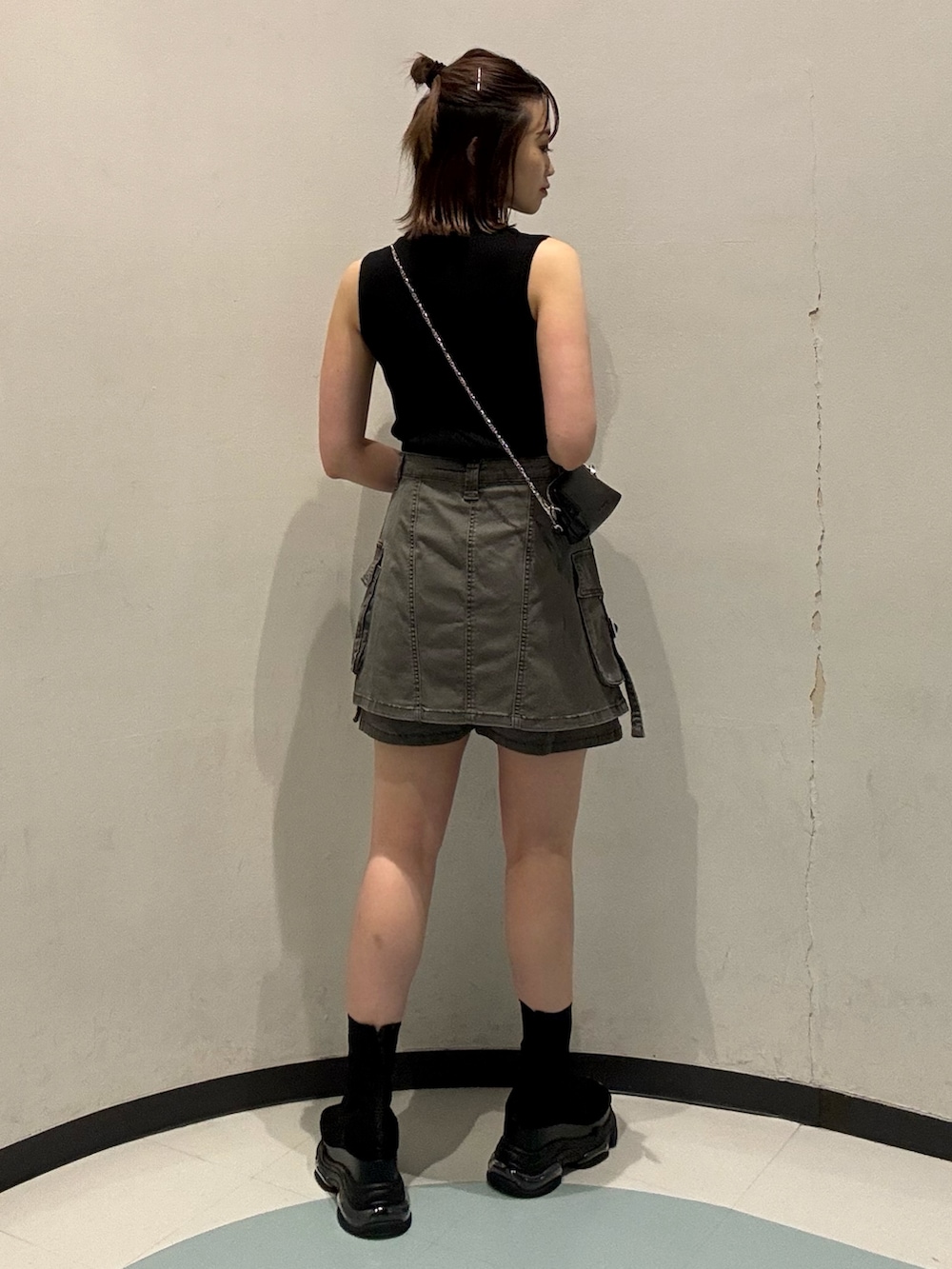 ブラック系のニット/セーター、ブラック系のサンダル、グレー系のスカートを着用したレディースの夏コーディネートの3枚目の写真