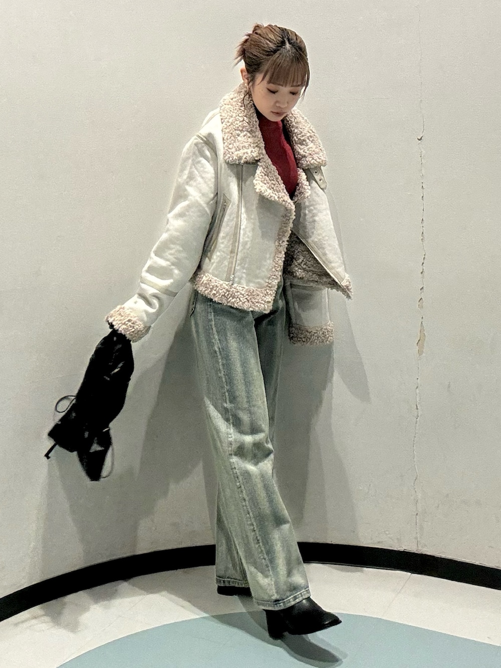 ブラック系のトートバッグ、ホワイト系のムートンコート、レッド系のニット/セーターを着用したレディースの秋コーディネートの2枚目の写真