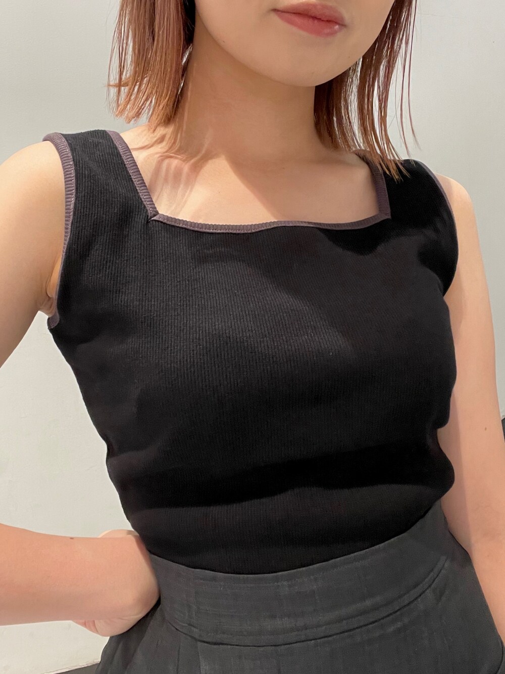 ブラック系のトレンチコート、グレー系のスカート、ブラック系のショルダーバッグを着用したレディースの夏コーディネートの3枚目の写真