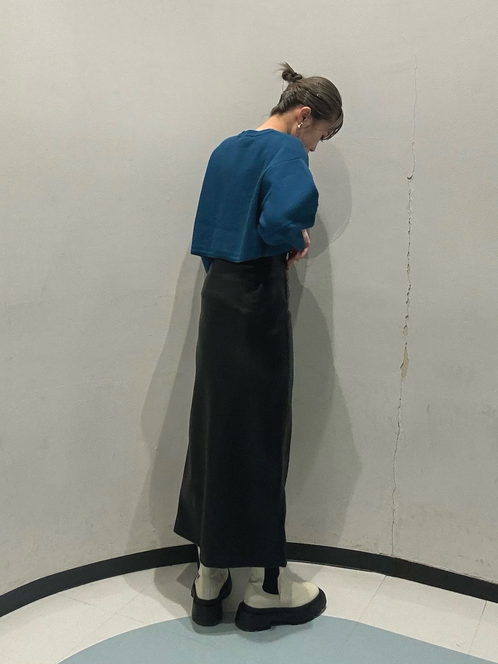 ホワイト系のブーツ、ブラック系のスカート、ブルー系のニット/セーターを着用したレディースの冬コーディネートの5枚目の写真