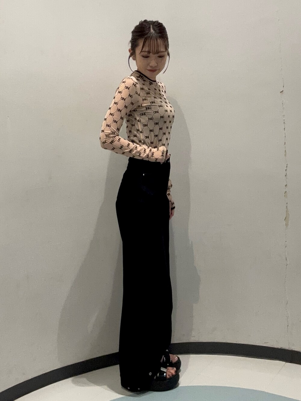 ブラック系のデニムパンツ、ベージュ系のTシャツ/カットソー、ブラック系のサンダルを着用したレディースの夏コーディネートの2枚目の写真