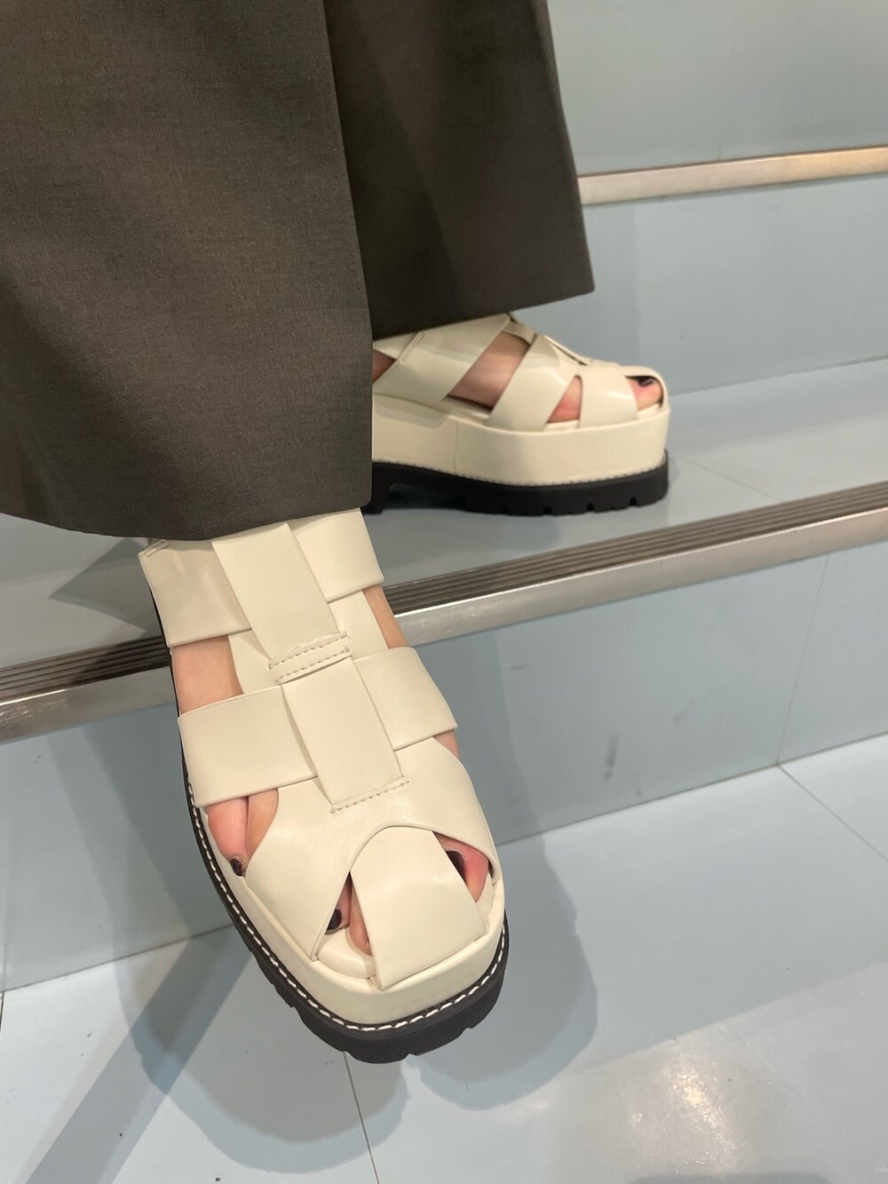 ホワイト系のサンダル、グレー系のスラックス、グレー系のテーラードジャケットを着用したレディースの春コーディネートの7枚目の写真