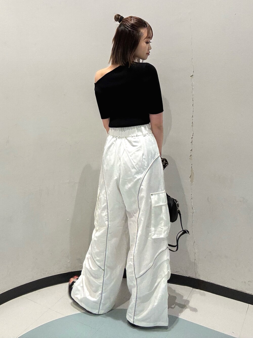 ブラック系のニット/セーター、ホワイト系のカーゴパンツ、ブラック系のサンダルを着用したレディースの春コーディネートの3枚目の写真