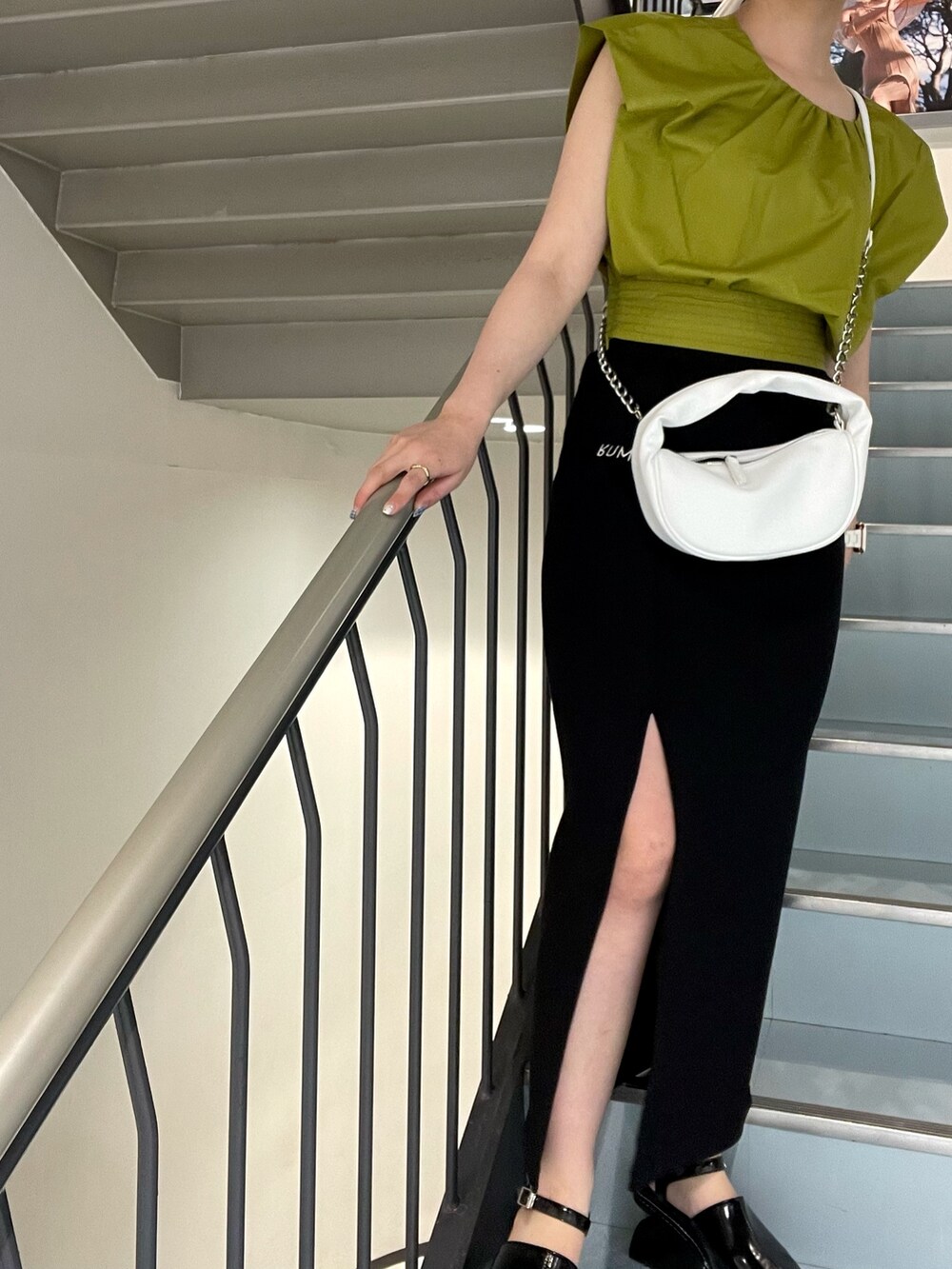 イエロー系のシャツ/ブラウス、ホワイト系のハンドバッグ、ブラック系のサンダルを着用したレディースの春コーディネートの6枚目の写真