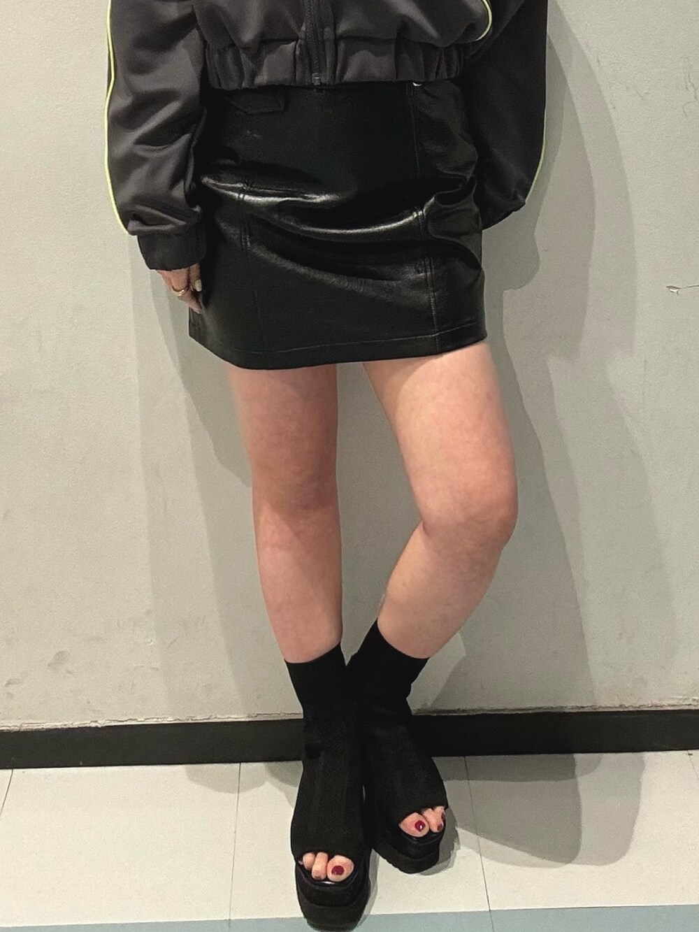 ブラック系のブーツ、グレー系のブルゾン、ブラック系のスカートを着用したレディースの春コーディネートの6枚目の写真