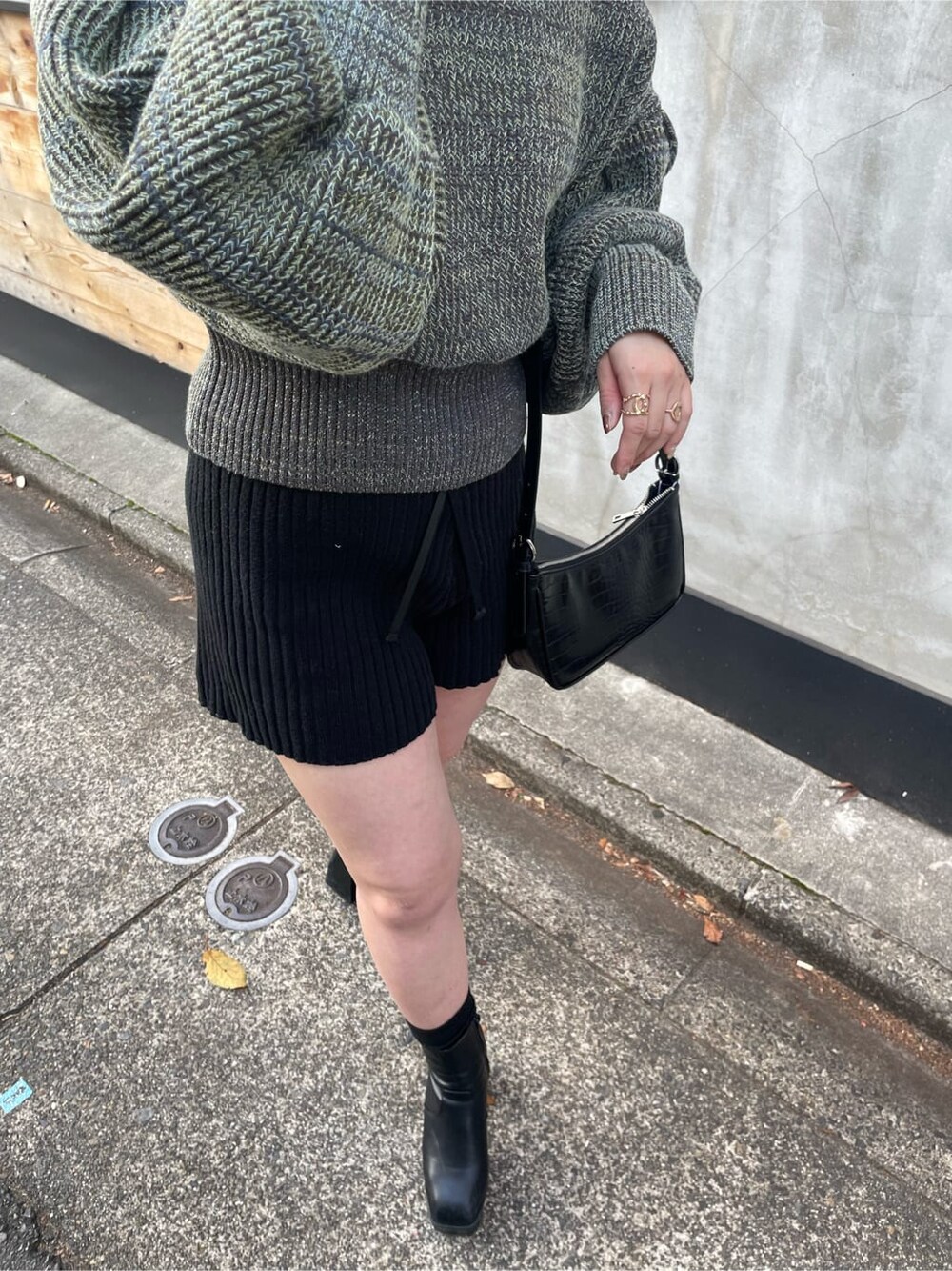 ホワイト系のカーディガン/ボレロ、ホワイト系のハンドバッグ、ブラック系のその他パンツを着用したレディースの冬コーディネートの3枚目の写真