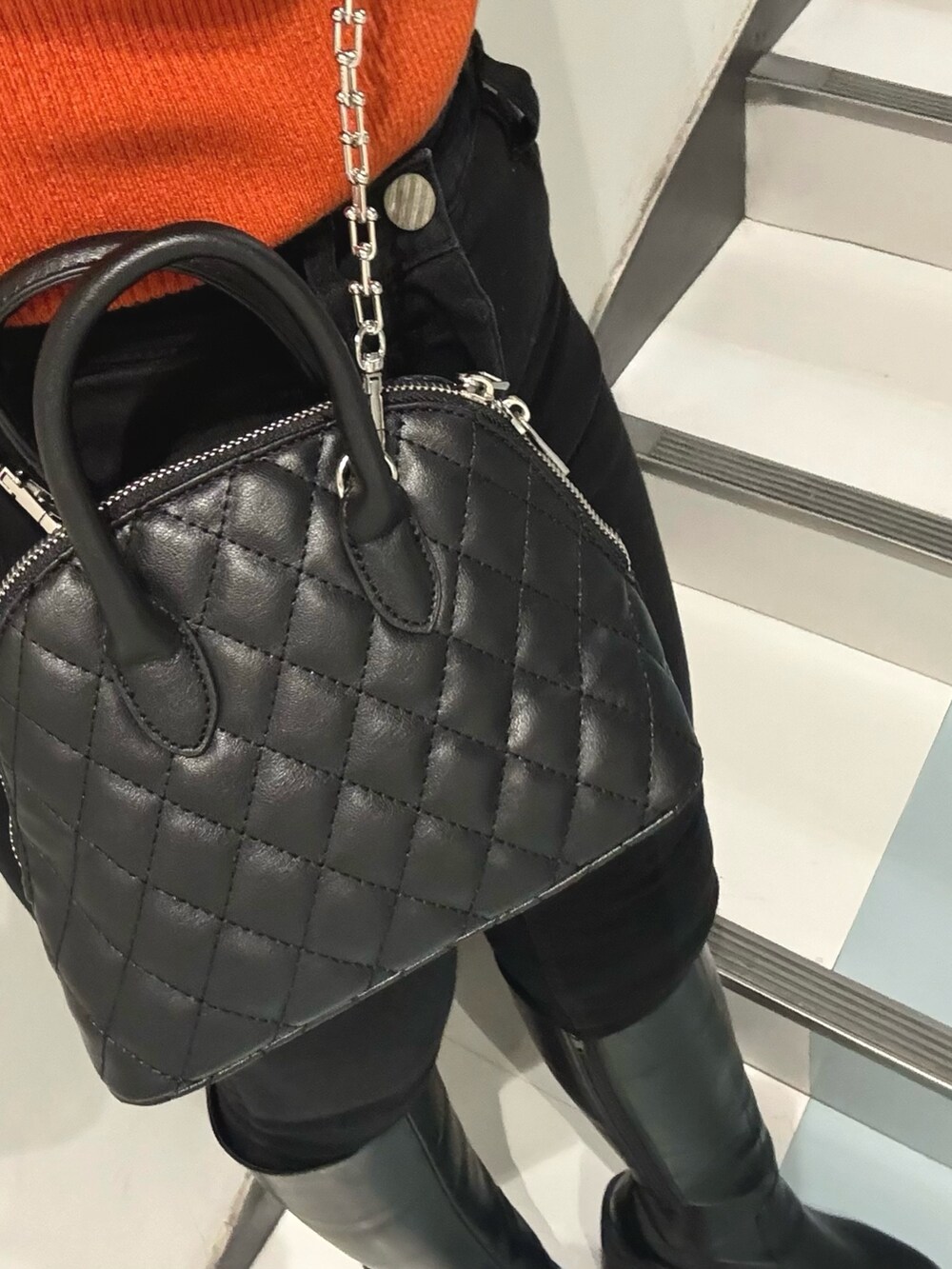 ブラック系のブーツ、ブラック系のハンドバッグ、ブラウン系のムートンコートを着用したレディースの冬コーディネートの6枚目の写真