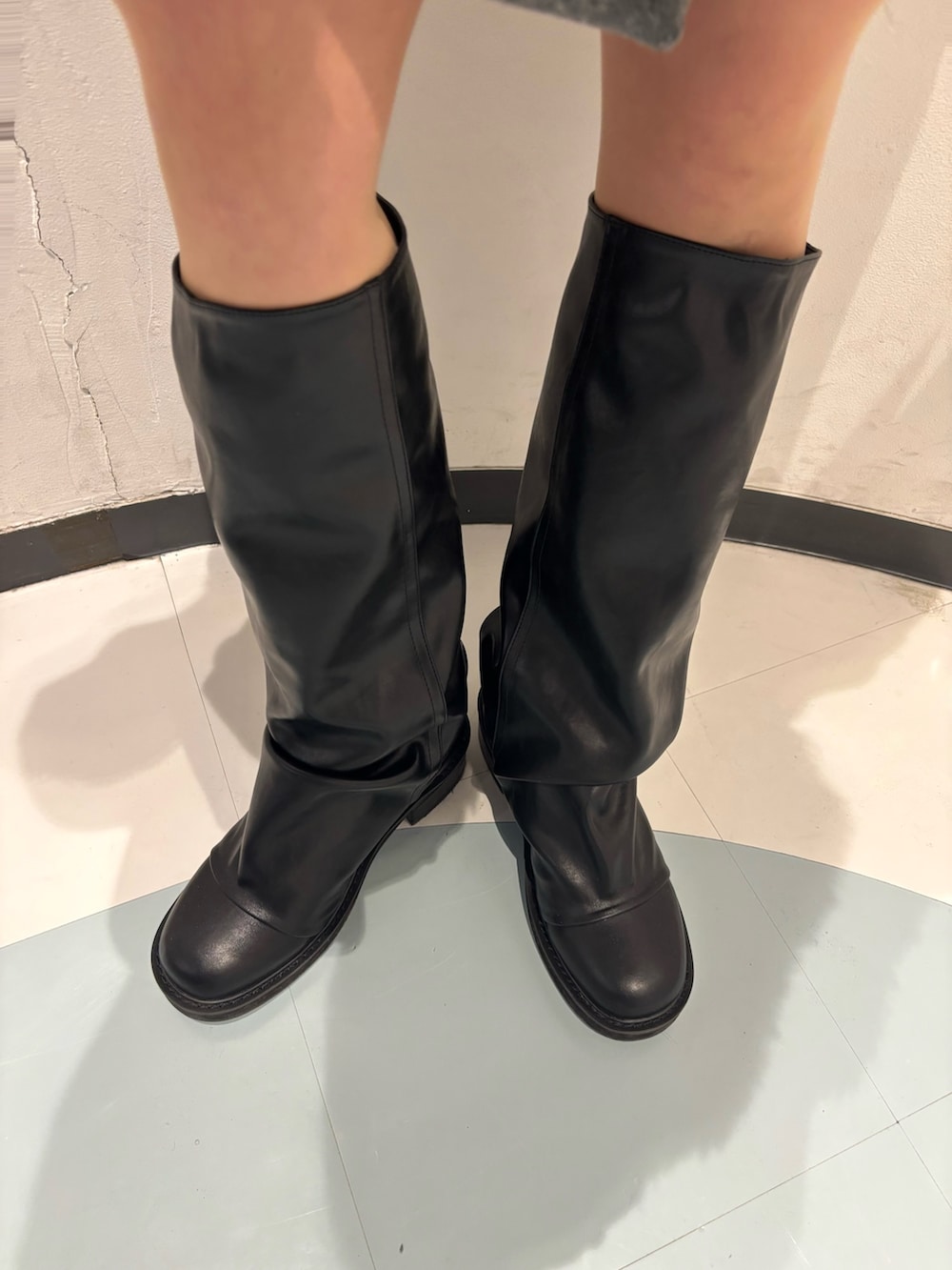 グレー系のスカート、ブラック系のブルゾン、ブラック系のニット/セーターを着用したレディースの冬コーディネートの7枚目の写真