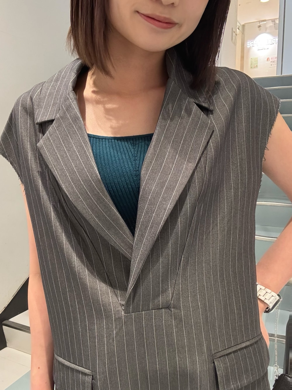 ブラック系のショルダーバッグ、ブラック系のサンダル、グレー系のワンピースを着用したレディースの夏コーディネートの6枚目の写真