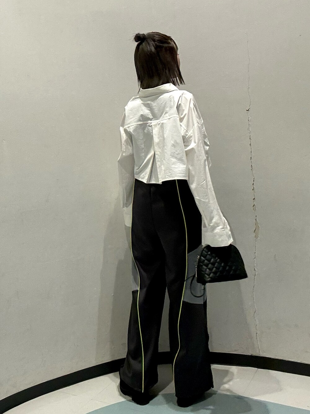 ブラック系のハンドバッグ、ブラック系のニット/セーター、グレー系のその他パンツを着用したレディースの春コーディネートの3枚目の写真